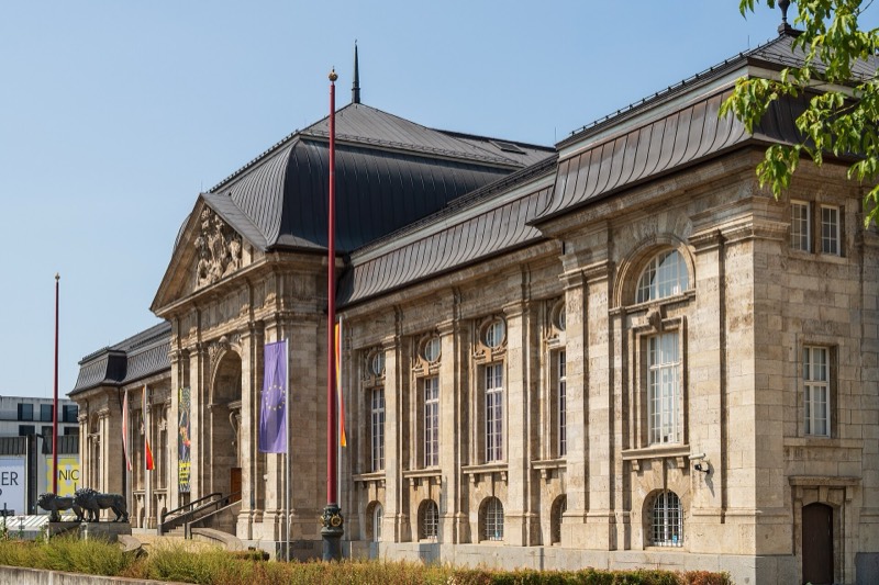 Sandsteinfassade des Hessischen Landesmuseums Darmstadt mit Giebelportal, Rundbogenfenstern und geschwungenen Dächern