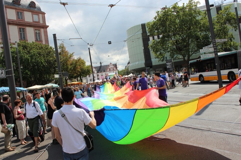 Christopher Street Day 2015 in Darmstadt: Demonstrierende tragen eine große Regenbogenfahne über die Straße