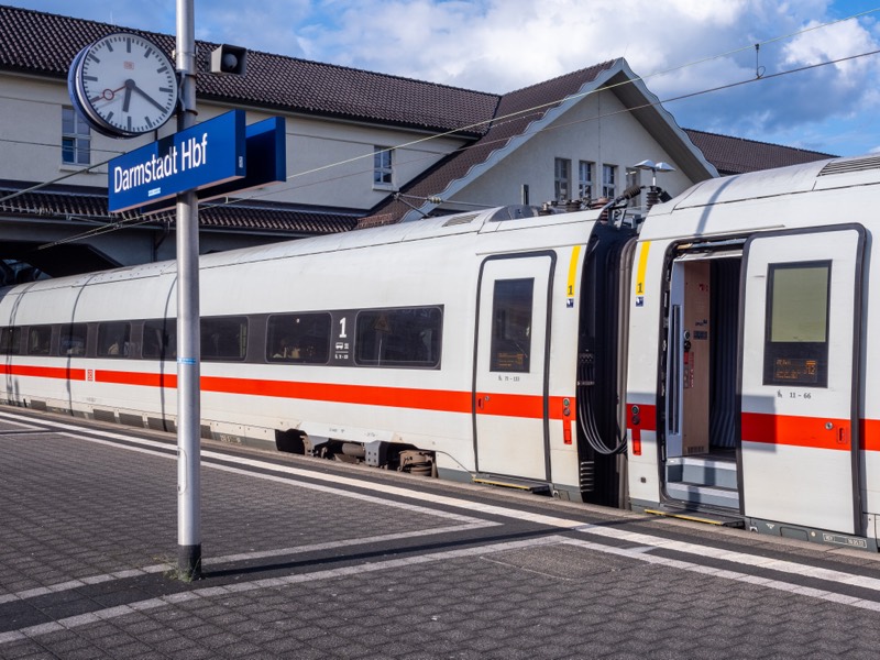 ICE am Bahnsteig im Darmstädter Hauptbahnhof mit Stationsschild und Bahnhofsuhr