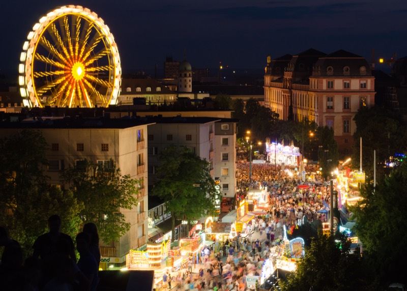 Heinerfest bei Nacht: beleuchtetes Riesenrad und volle Festmeile in der Darmstädter Innenstadt, rechts das Residenzschloss