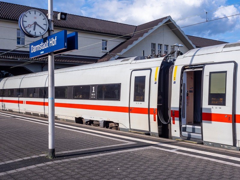 ICE am Bahnsteig im Darmstädter Hauptbahnhof, links das Bahnsteigschild „Darmstadt Hbf“ und die Bahnhofsuhr