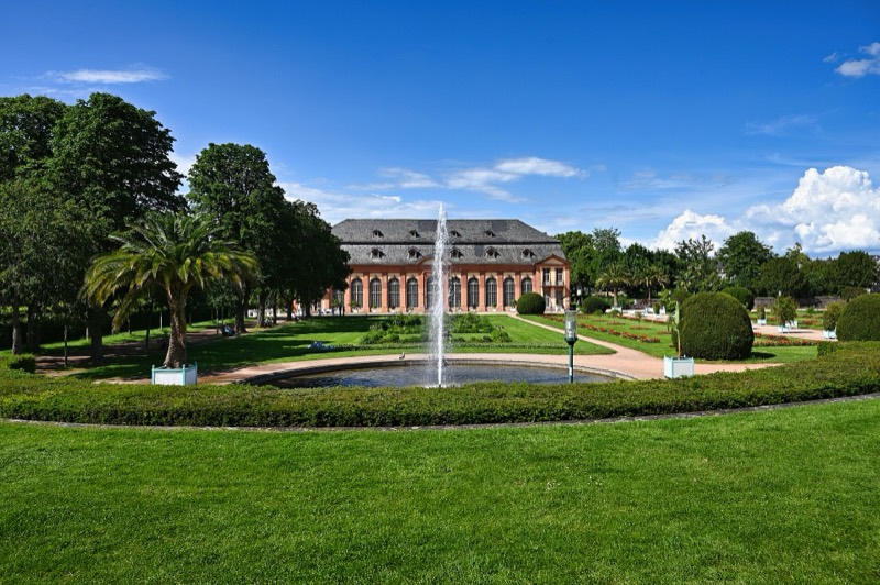 Orangeriegarten in Darmstadt-Bessungen mit Springbrunnen, Rasenparterre, Palmen und dem barocken Orangeriegebäude