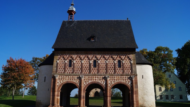 Karolingische Torhalle von Kloster Lorsch mit rot-weißer Steinfassade unter blauem Himmel, ein lohnender Zwischenstopp auf der Radtour Richtung Heidelberg