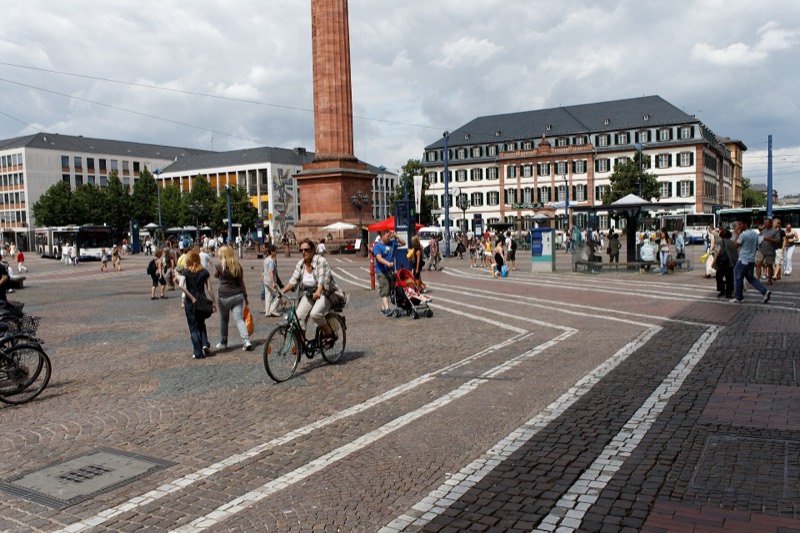 Luisenplatz in Darmstadt mit der Ludwigssäule („Langer Ludwig“), Passanten und Radfahrern