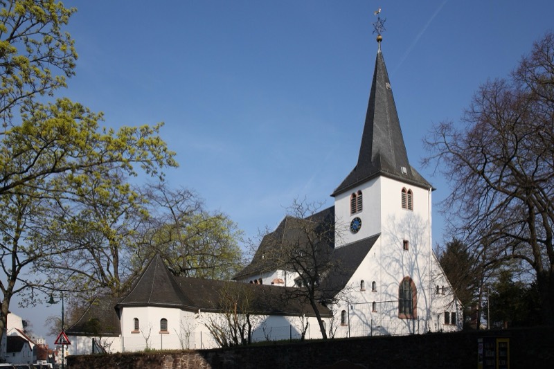 Die weiße Bessunger Kirche mit spitzem Schieferturm in Darmstadt-Bessungen im Frühling