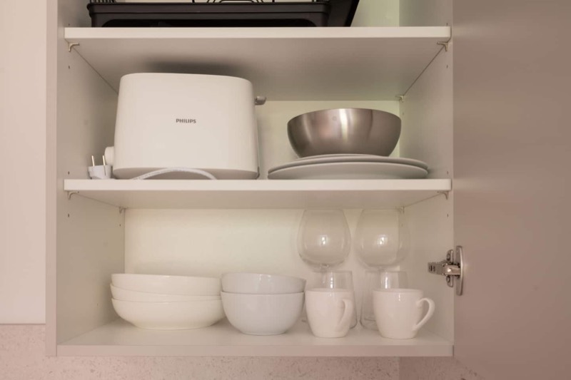 Studio 1 – Geschirrschrank mit Toaster, Tellern und Gläsern