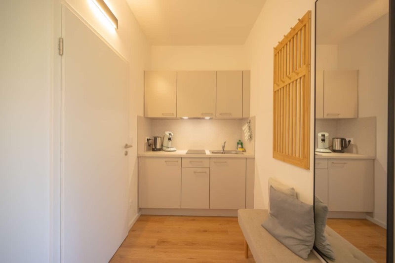 Studio 2 – Küchenzeile im Eingangsbereich mit Spiegel und Garderobe