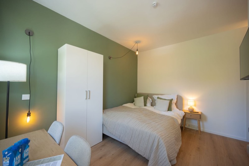 Studio 2 – Doppelbett mit Kleiderschrank und Stehlampe