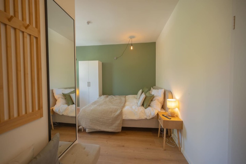 Studio 2 – Doppelbett im Spiegel mit grüner Wand
