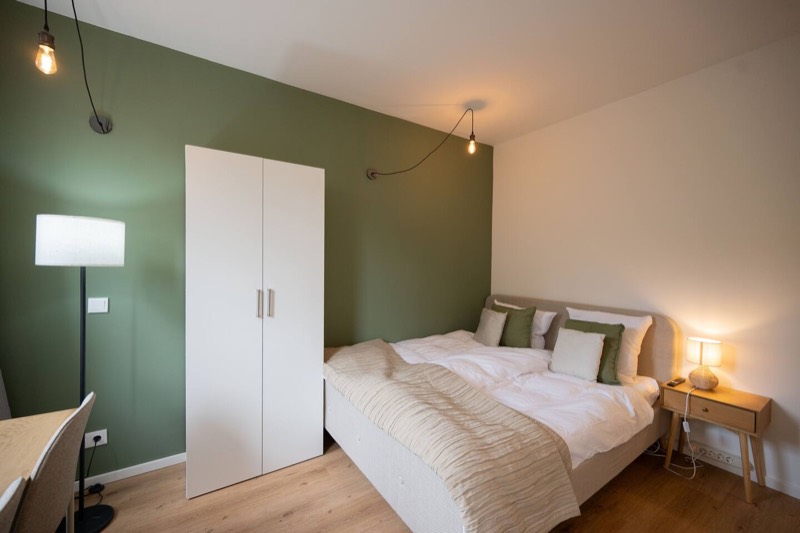 Studio 2 – Doppelbett neben weißem Kleiderschrank